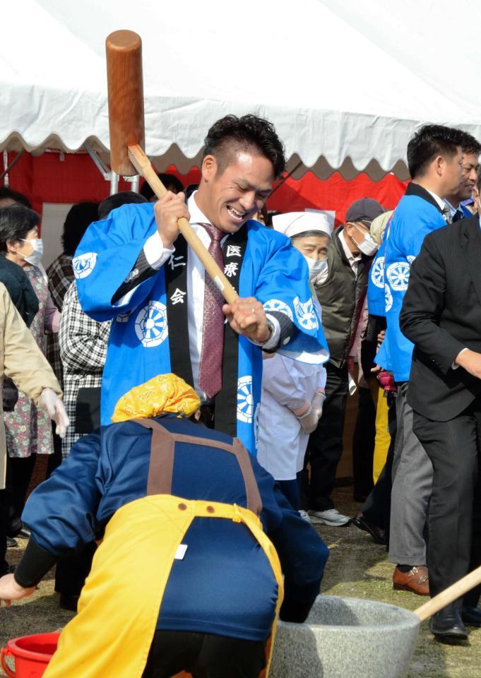 　笑顔で餅つきを行う田中