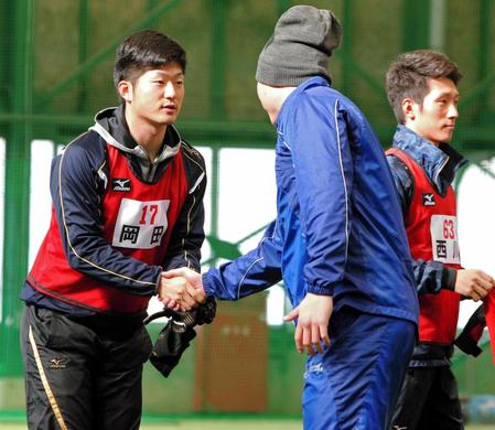 　新井（右）にあいさつする岡田（撮影・吉澤敬太）