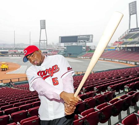 　背番号５のユニホームに袖を通し、笑顔でバットを振るルナ（撮影・吉澤敬太）