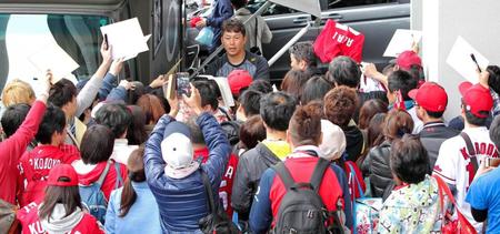 　大勢のファンに囲まれてサインする新井（中央奥）