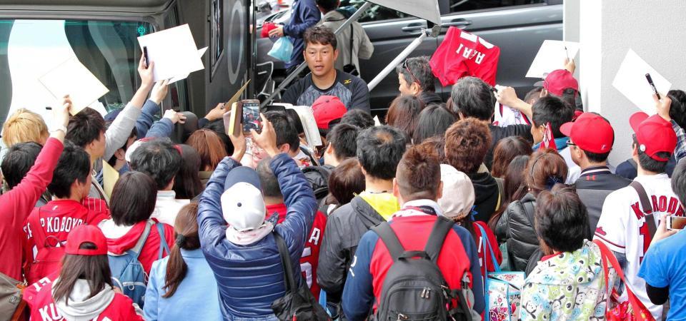 　大勢のファンに囲まれてサインする新井（中央奥）