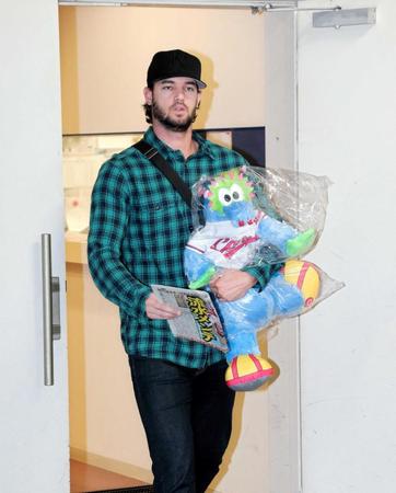 　雨天中止になり、スラィリーとデイリースポーツを手に帰途に就くジョンソン（撮影・吉澤敬太）