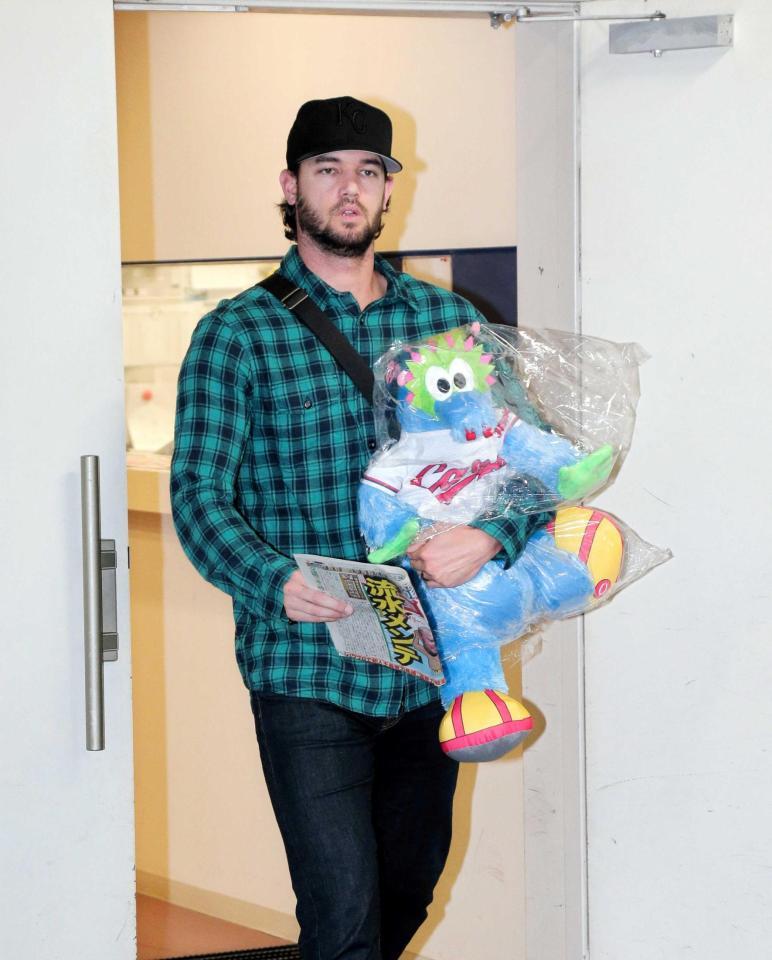 　雨天中止になり、スラィリーとデイリースポーツを手に帰途に就くジョンソン（撮影・吉澤敬太）