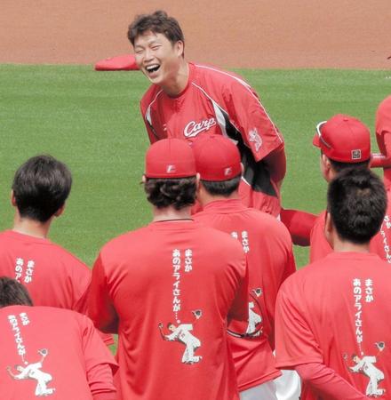 練習前「まさか　あのアライさんが…。」と書かれたＴシャツを着たナインらに出迎えられ、笑う広島・新井貴浩（上）＝マツダスタジアム（撮影・吉澤敬太）