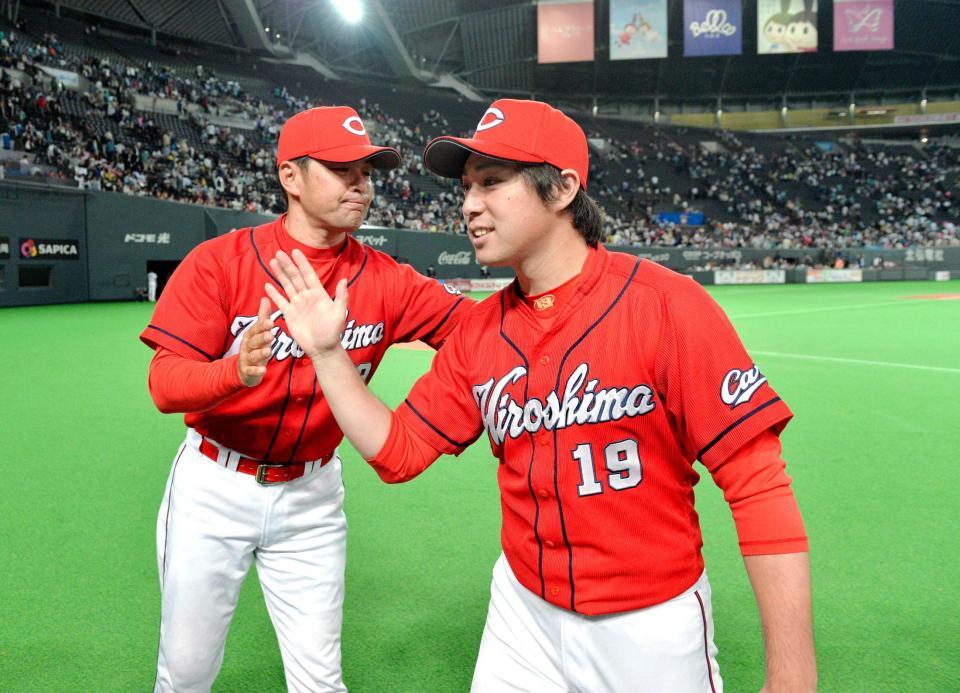 ７勝目を挙げ、緒方監督（左）に祝福される野村　　