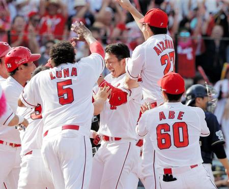 ９回、鈴木誠也（中央）は、左越えに２試合連続となる逆転サヨナラ３ランアーチを放ち、仲間から祝福される＝マツダスタジアム（撮影・吉澤敬太）