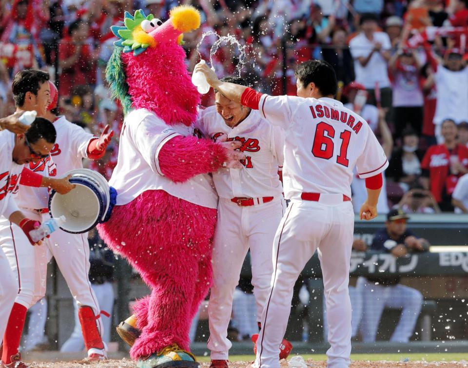 ９回広島１死一、三塁、鈴木誠也（中央）は、左越えに２試合連続となる逆転サヨナラ３ランアーチを放ち、仲間から祝福される＝マツダスタジアム（撮影・吉澤敬太）