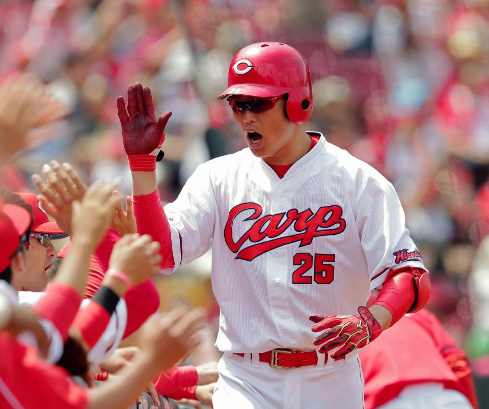 左越えに先制ソロを放ち、ナインとタッチを交わす広島・新井＝マツダスタジアム（撮影・吉澤敬太）