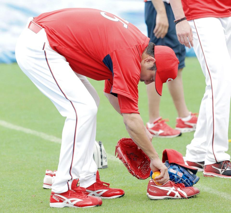 　練習前、野村のスパイクにみかんを入れる黒田（撮影・吉澤敬太）