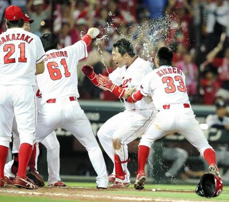 ９回広島１死、右越えにサヨナラ本塁打を放ちナインから手荒い祝福を受ける新井貴浩＝マツダスタジアム（撮影・持木克友）