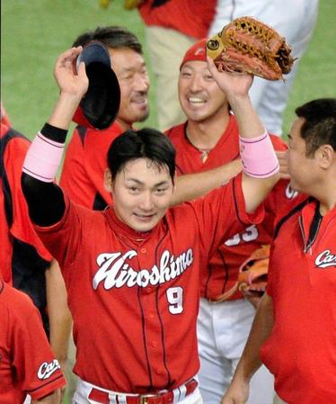 菊池涼介（後方）と笑顔をも見せる広島・丸佳浩＝東京ドーム（撮影・西岡正）