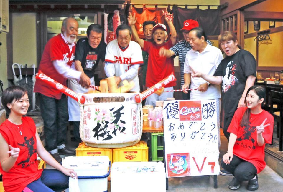 　２５年ぶりの優勝を祝い鏡開きをする安仁屋氏（後列左端）と東為五郎（同３人目）