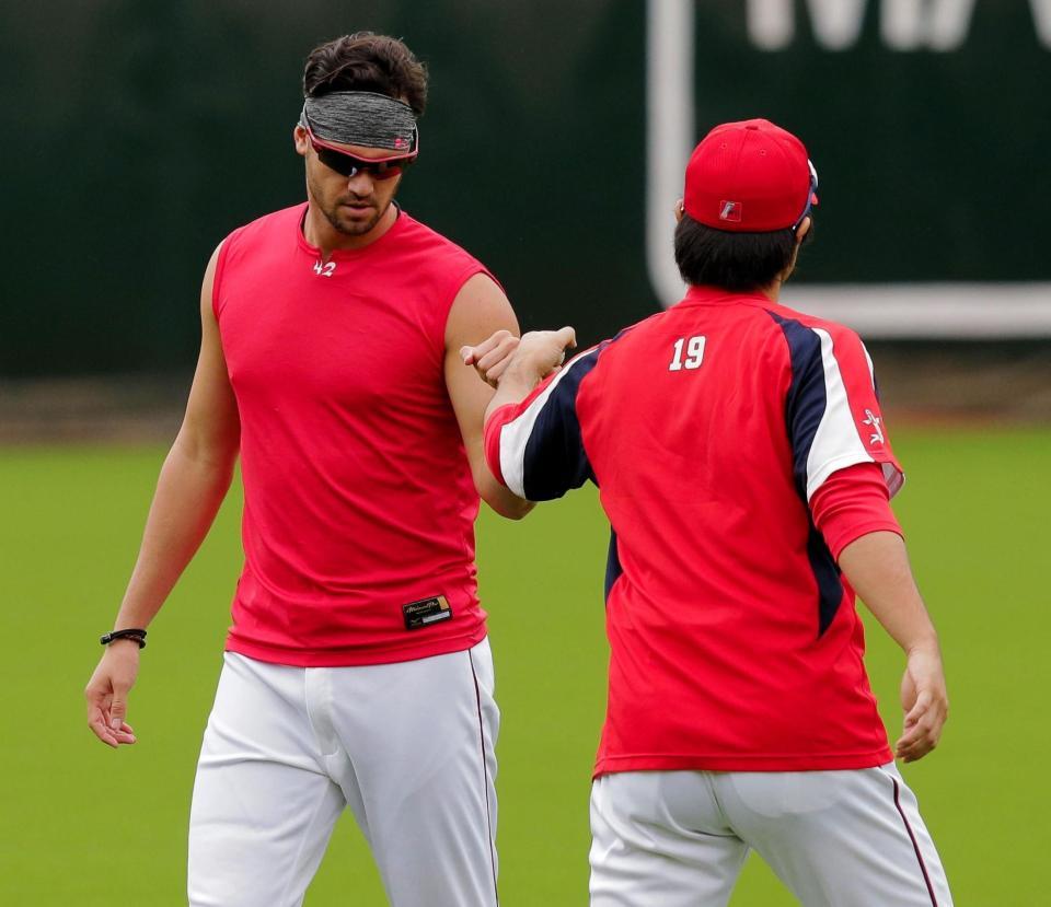 練習中、タッチを交わすジョンソンと野村（右）＝マツダスタジアム（撮影・吉澤敬太）