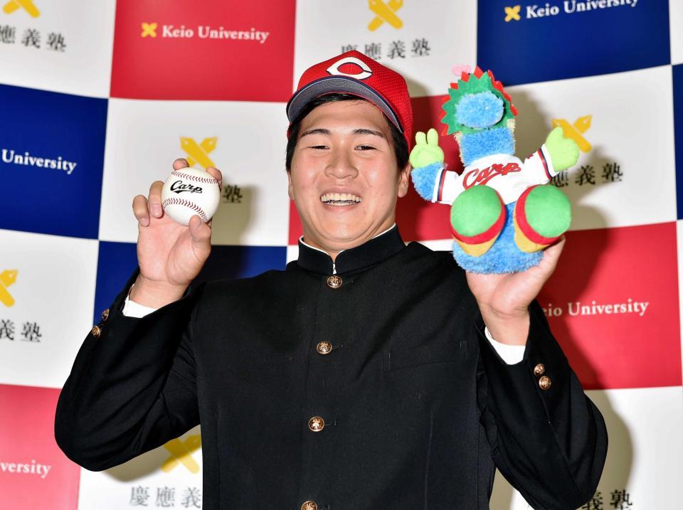 　広島から１位指名を受け笑顔でポーズを決める慶大・加藤（撮影・園田高夫）