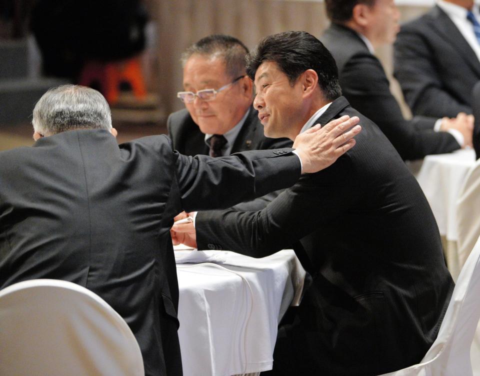 　２度の抽選に敗れ、松田オーナー（左）から慰められる緒方監督（撮影・西岡正）