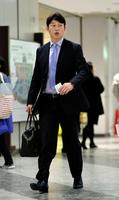 バッグを手に帰広する広島・新井貴浩＝北海道・新千歳空港