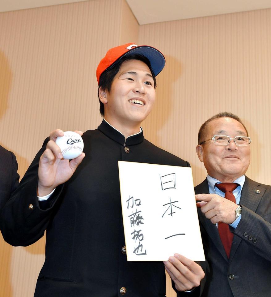 　『日本一』と書いた色紙を手に笑顔の加藤。右は苑田スカウト統括部長