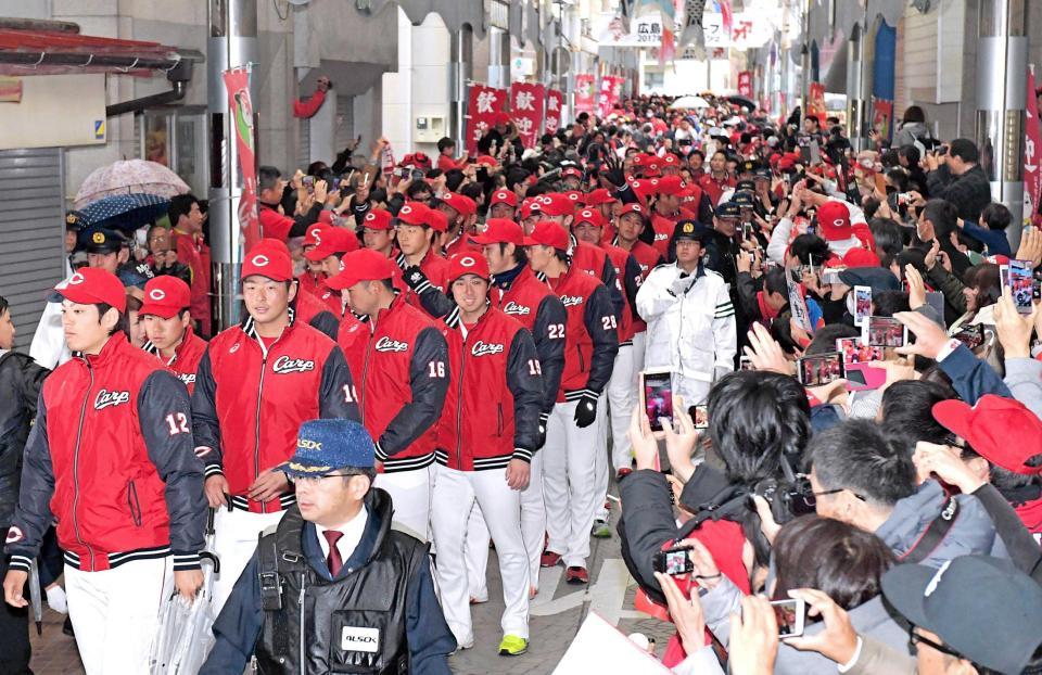 　日南市民らの声援を受け、笑顔でパレードを行う広島ナイン