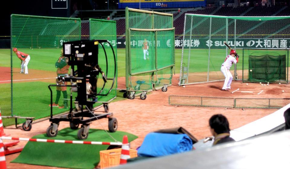 台を使って高い位置に設定した打撃マシンと向き合う丸（右）＝撮影・吉澤敬太　