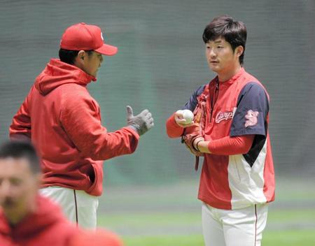 　練習中、緒方監督（左）と話す岡田