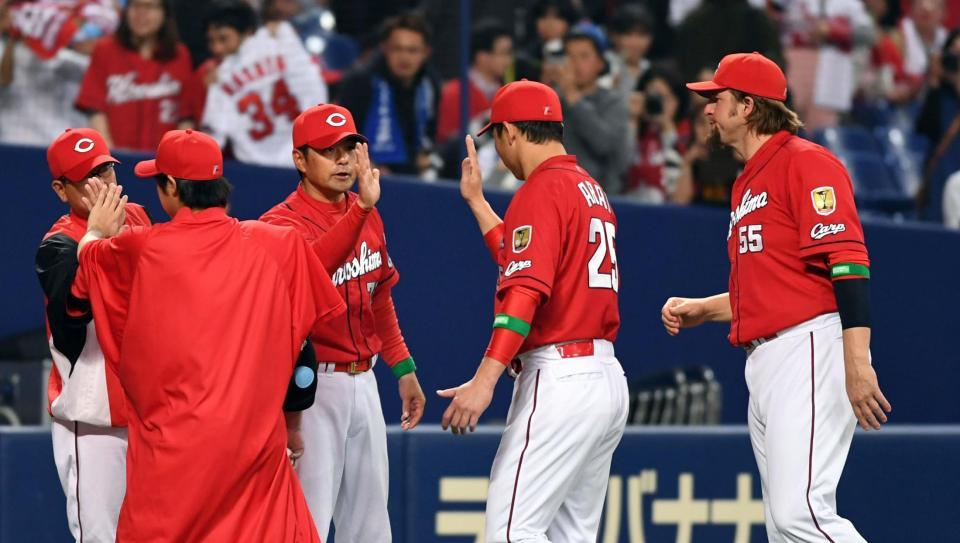 広島・緒方孝市監督（右から３人目）は広島・新井貴浩らナインと勝利のタッチをする＝ナゴヤドーム（撮影・山口登）