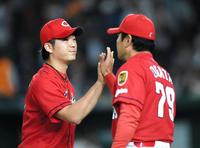 広島・緒方孝市監督（右）とタッチする広島・岡田明丈＝東京ドーム（撮影・棚橋慶太）