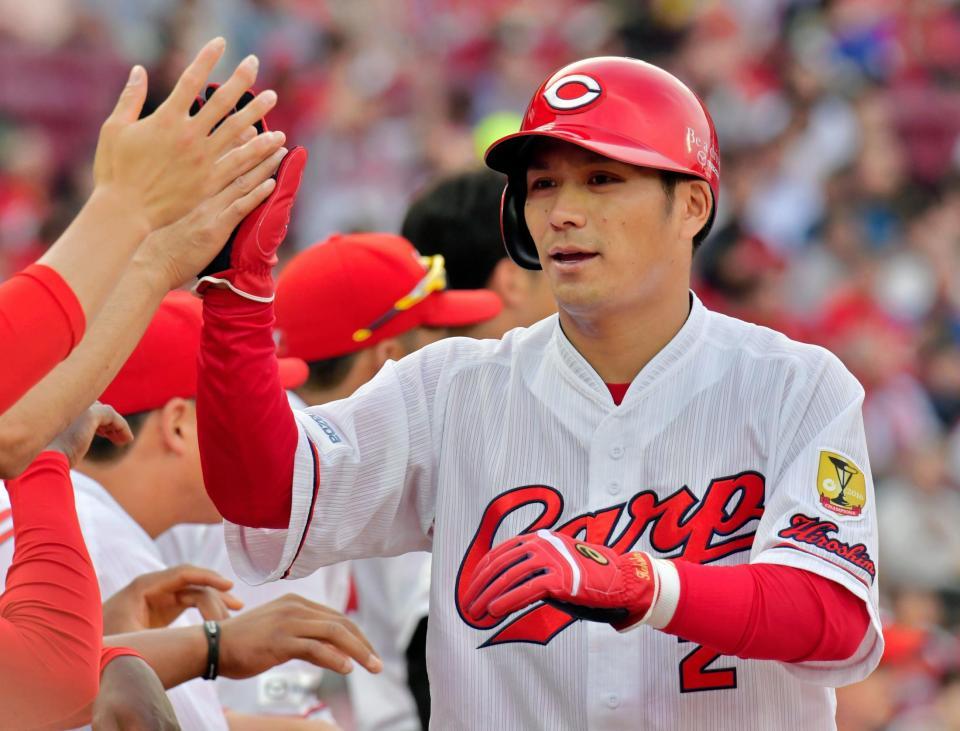 １回、丸の先制適時打で生還し、ナインとタッチを交わす田中