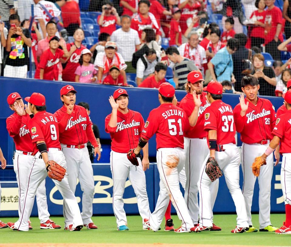　Ｍ３３を点灯させ、タッチを交わす緒方監督（７９）、野村（１９）ら広島ナイン（撮影・吉澤敬太）