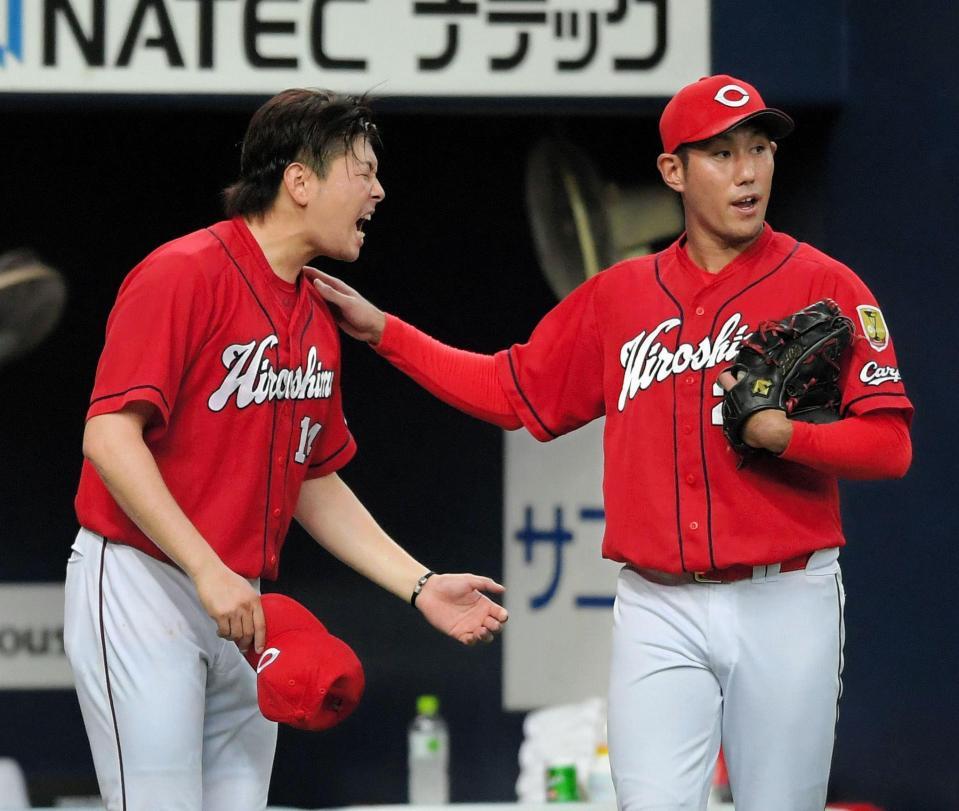 　６回途中から登板した広島・中田（右）に肩をたたかれた大瀬良だが、デッドボールの影響か苦痛に顔をゆがめる