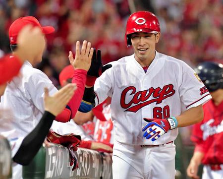 　７回、ソロを放ち、ナインと笑顔でタッチを交わす安部