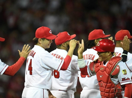 最終戦で２桁勝利を挙げた大瀬良は好リードの磯村とタッチを交わす