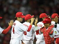 最終戦で二ケタ勝利を挙げた広島・大瀬良大地は好リードの広島・磯村嘉孝とタッチを交わす＝マツダスタジアム（撮影・田中太一）