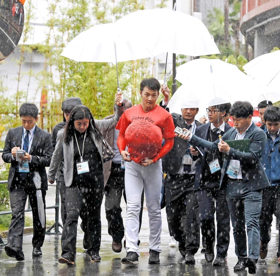 　雨の中、室内練習場から引き揚げる薮田（中央）＝撮影・堀内翔
