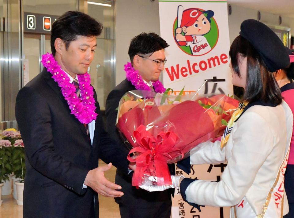日南サンフレッシュレディから花束とレイを贈られる緒方監督と会沢（中央）＝宮崎空港