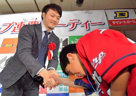 ファンにサインボールをプレゼントし、笑顔で握手する薮田（左）＝撮影・吉澤敬太　