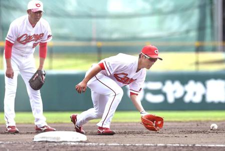 　玉木コーチ（左）の指導のもとノックを受ける西川