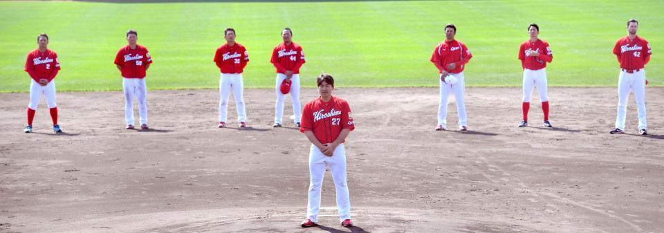 円陣の中心であいさつする広島・会沢翼＝コザしんきんスタジアム（撮影・飯室逸平）