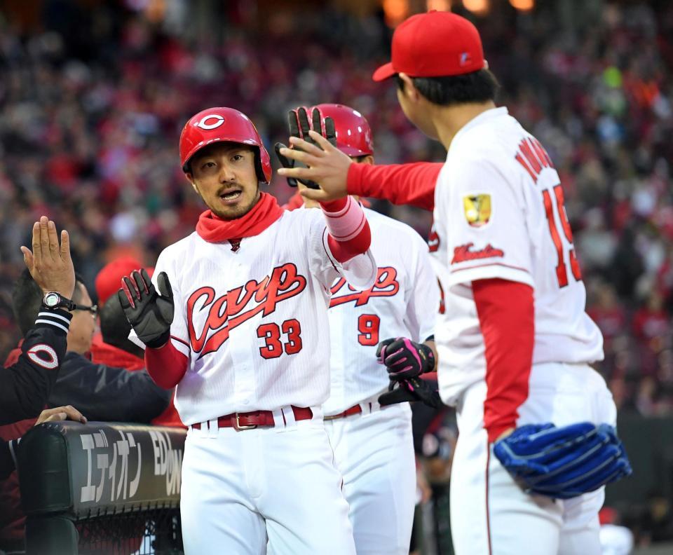 １回、勝ち越しのホームを踏み、広島・野村祐輔とハイタッチをかわす広島・菊池涼介＝マツダスタジアム（撮影・飯室逸平）