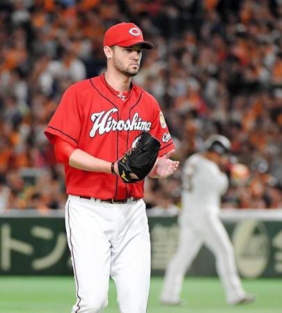 ４回、巨人・岡本（後方）を併殺に打ち取りグラブをたたく広島のジョンソン＝東京ドーム（撮影・堀内翔）