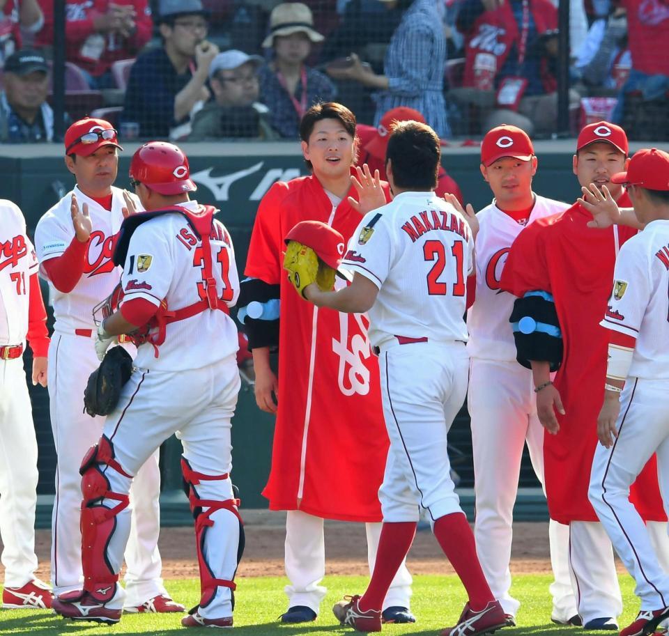 阪神に勝利し、ナインとタッチを交わす広島・大瀬良大地（中央）＝マツダスタジアム（撮影・高部洋祐）