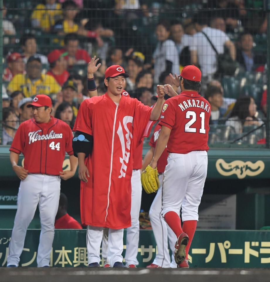 ８回、ピンチをしのいだ広島・中崎翔太（２１）を迎える広島・大瀬良大地（中央）＝甲子園（撮影・北村雅宏）