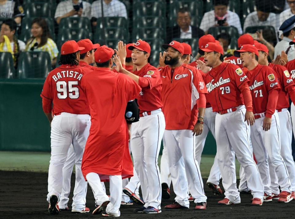 広島・大瀬良大地（中央左）は１０勝目を挙げ笑顔でナインとタッチする＝甲子園（撮影・山口登）