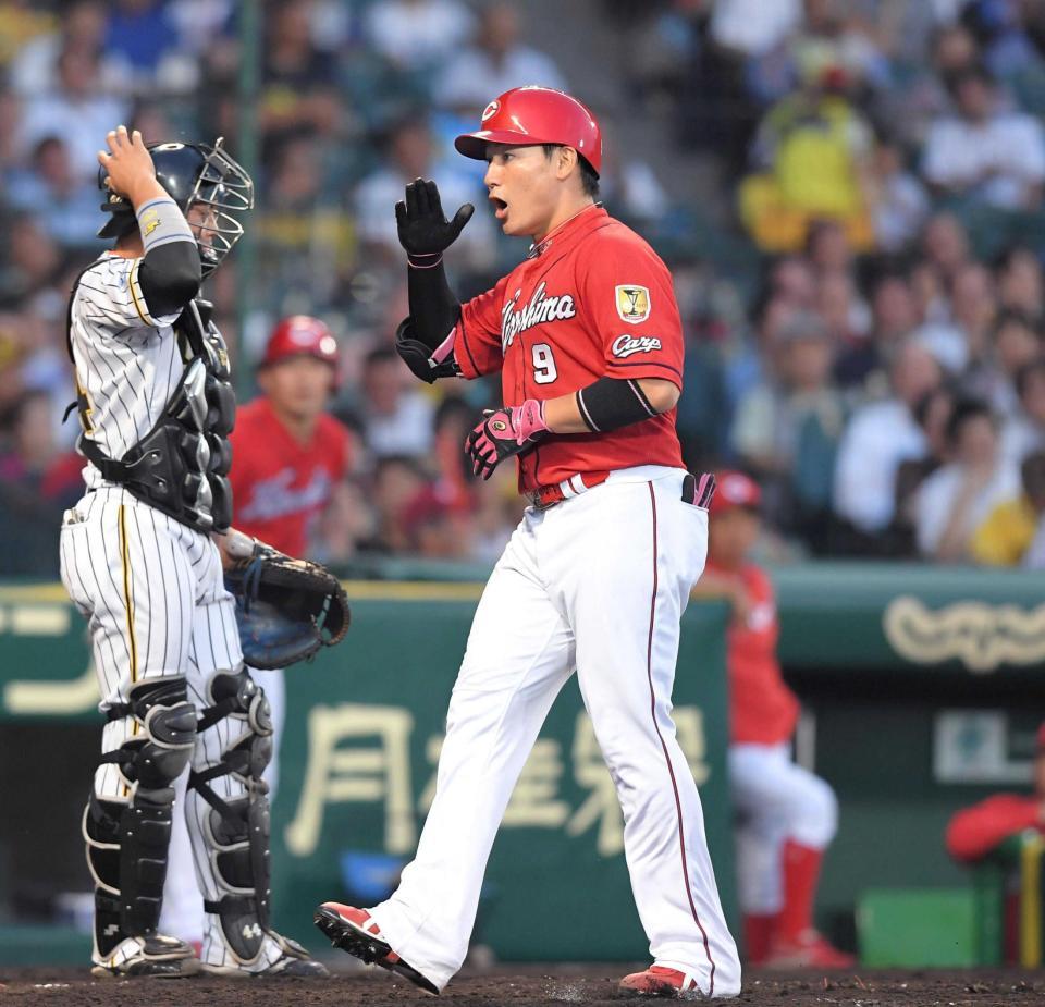 ４回、右越えに先制となるソロを放ち、敬礼ポーズで生還する丸。左は捕手・梅野（撮影・北村雅宏）　