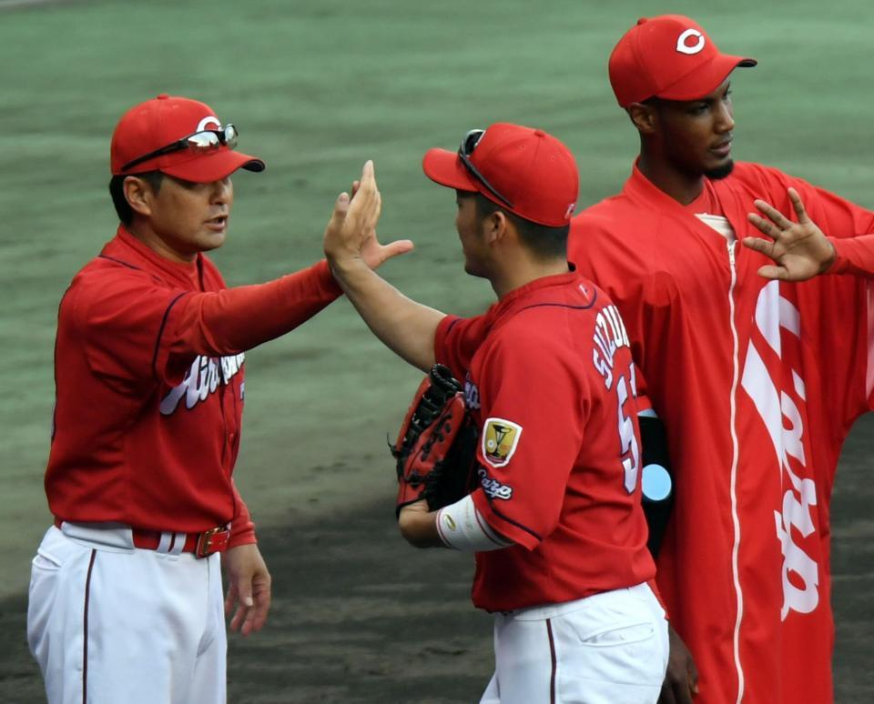 阪神に３連勝し広島・緒方監督（左）は鈴木誠也とタッチする（右はアドゥワ誠）＝甲子園（撮影・山口登）