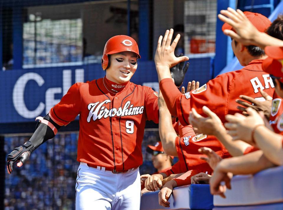 　４回、左越えソロを放ち、笑顔でナインとタッチを交わす丸（撮影・中田匡峻）