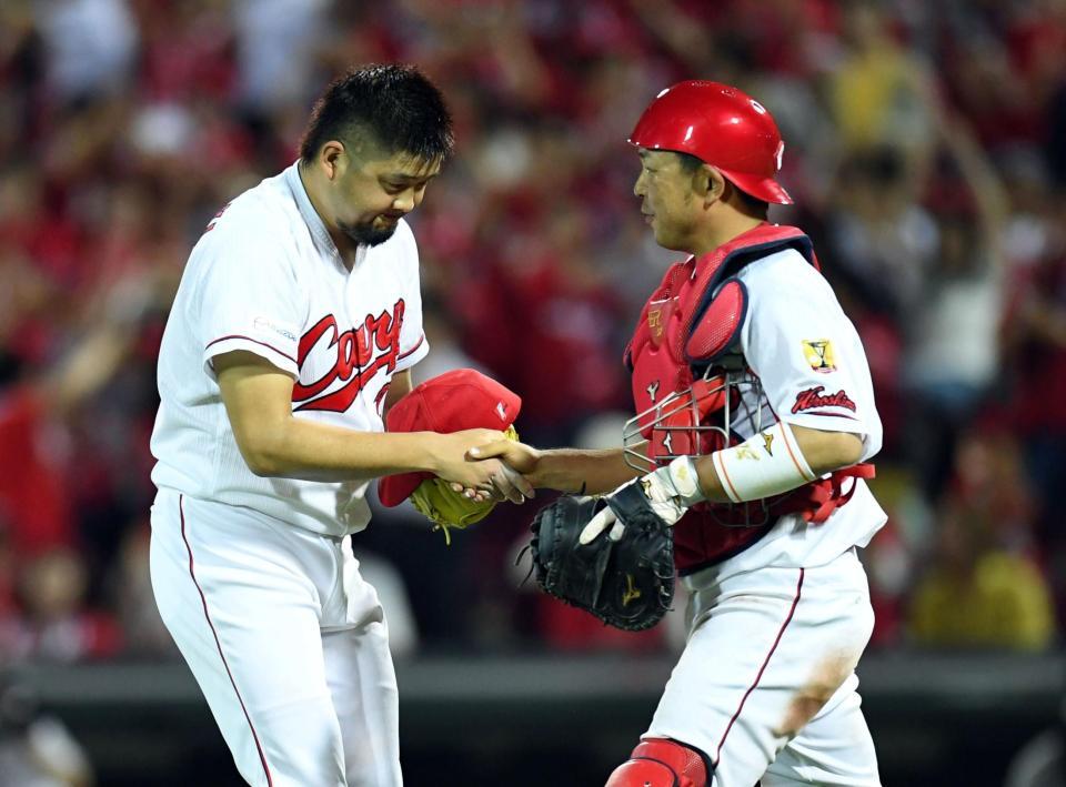 最後を締め石原と握手をかわす広島・中崎翔太＝マツダスタジアム（撮影・飯室逸平）
