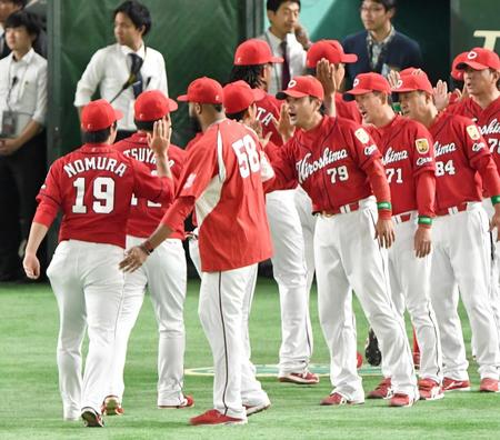 巨人に勝利し広島・野村祐輔（１９）らナインとタッチする広島・緒方孝市監督＝東京ドーム（撮影・金田祐二）