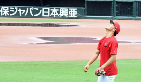 　雨天中止となり、水の浮いたグラウンドを横目にキャッチボールする薮田（撮影・飯室逸平）