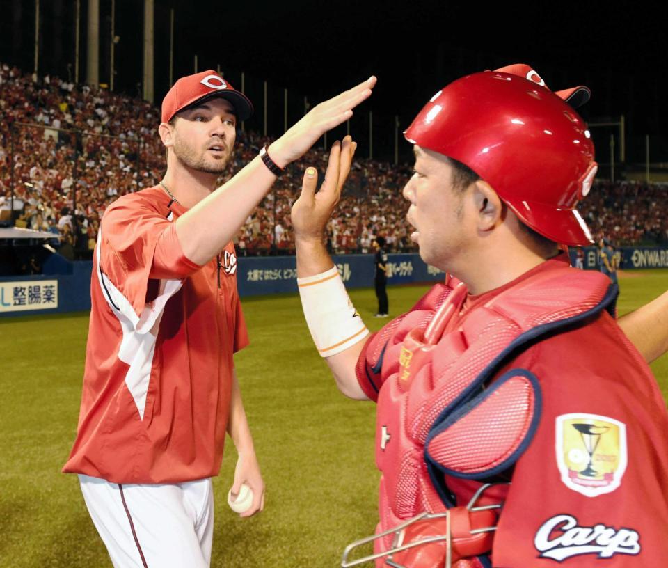 　ウイニングボールを手に石原（右）を笑顔で出迎えるジョンソン（撮影・棚橋慶太）