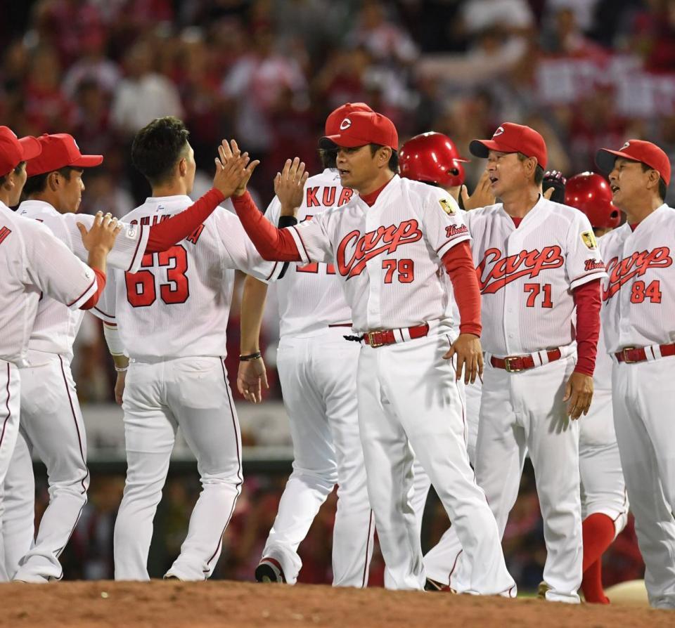 　勝利のハイタッチを交わす緒方監督（中央）ら（撮影・飯室逸平）